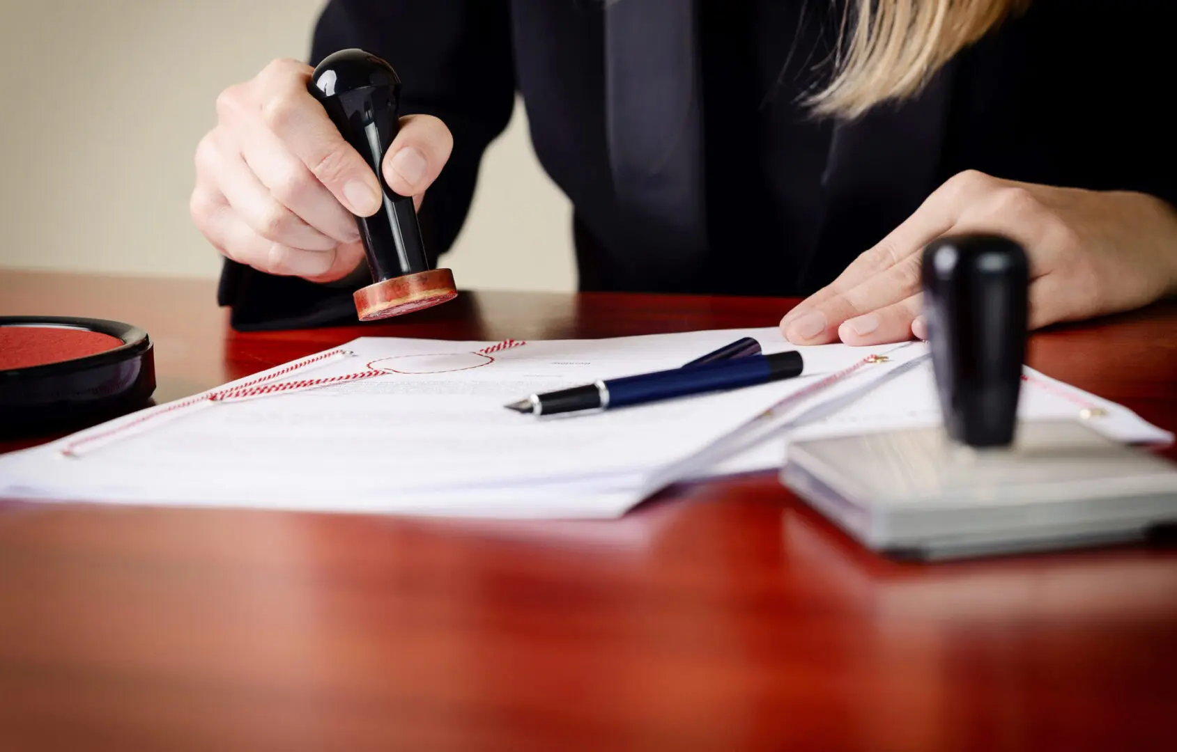 Person stamping documents at a desk.