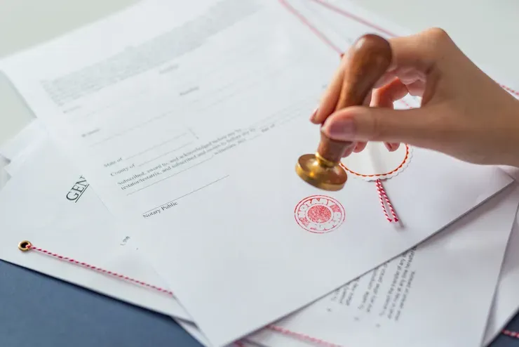 Hand stamping official documents with seal.
